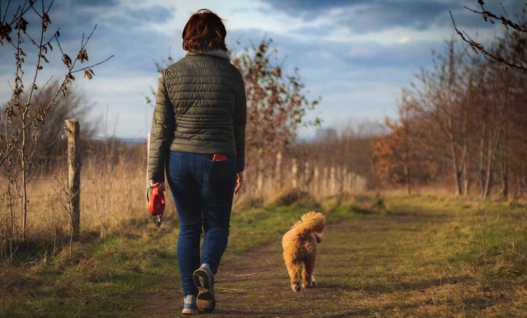 Woman walking on a path with her dog.