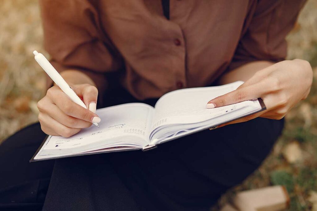 Woman writing in a notebook.