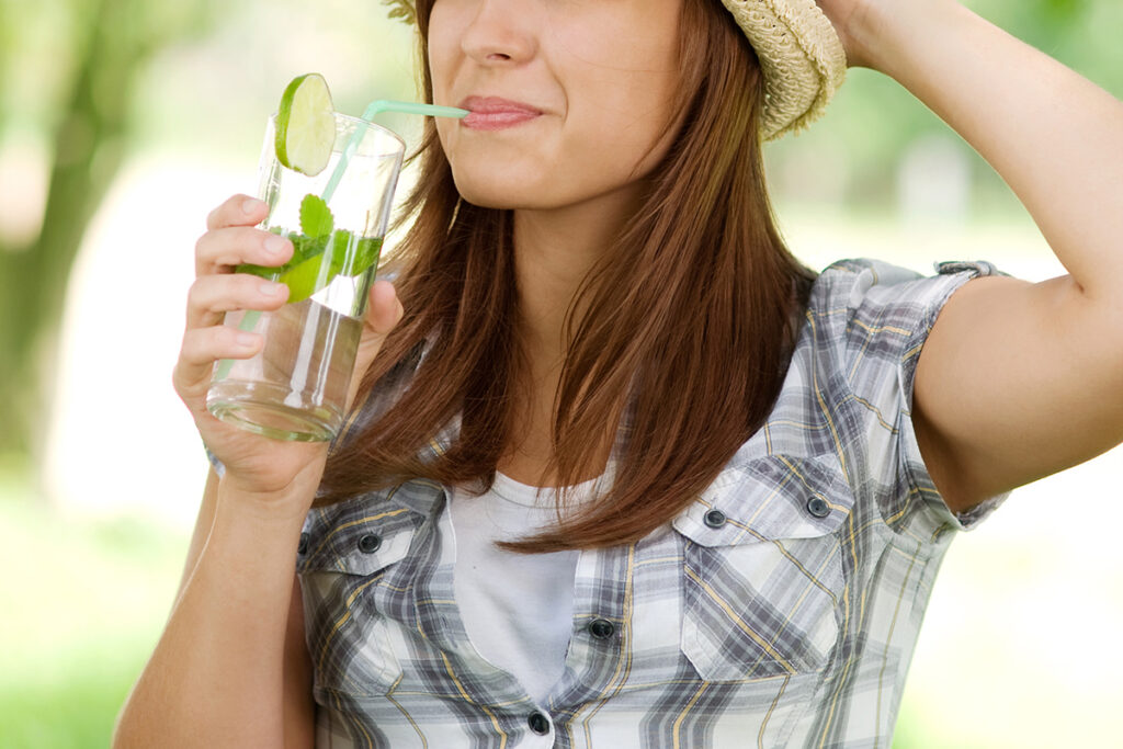 Young woman drinking flavored water.