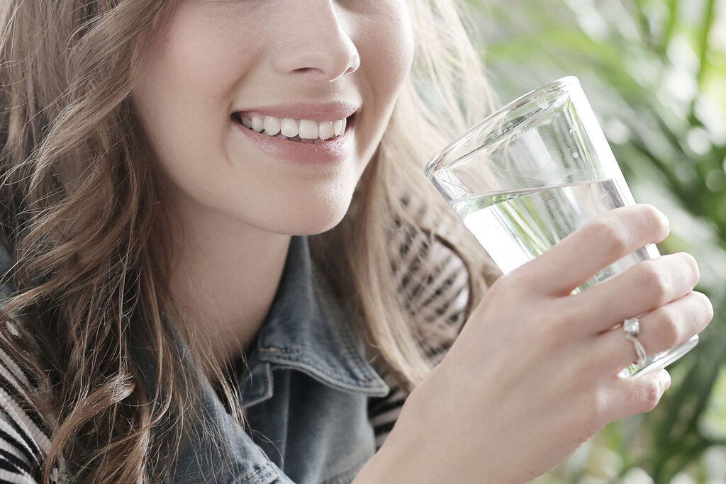 Young blond woman drinking water.