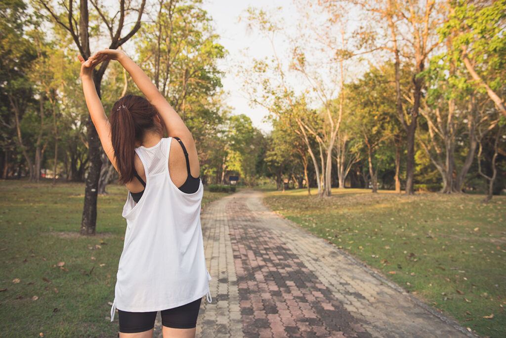 Young woman stretching while exercising outdoors. 